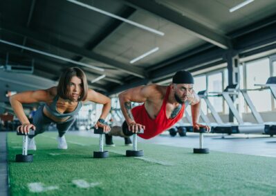 Focused Gym Goers, a Perfect Fitness Duo, Work Out with Dumbbells